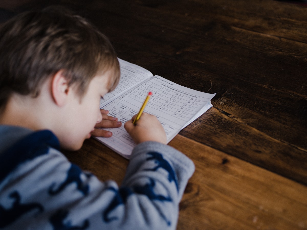 Parent and child sitting together at a table reviewing schoolwork — representing collaborative support in ADHD evaluation and treatment